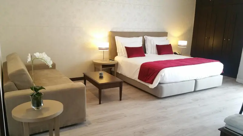 Une chambre lumineuse avec un lit double et un canapé.