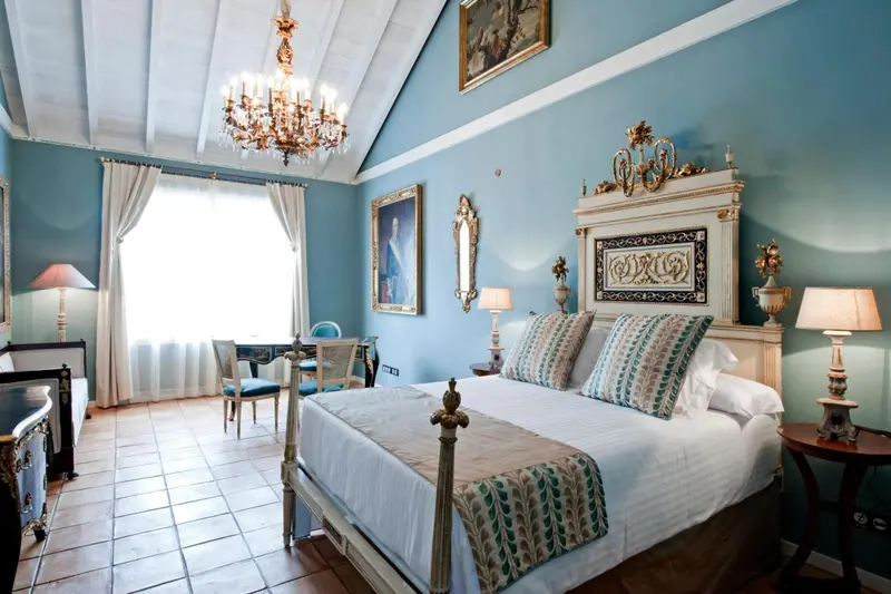 Une chambre lumineuse avec un grand lit à baldaquin et une décoration classique.