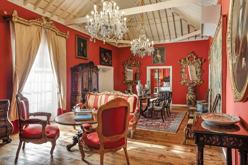 Une salle richement décorée avec des meubles anciens et des lustres.