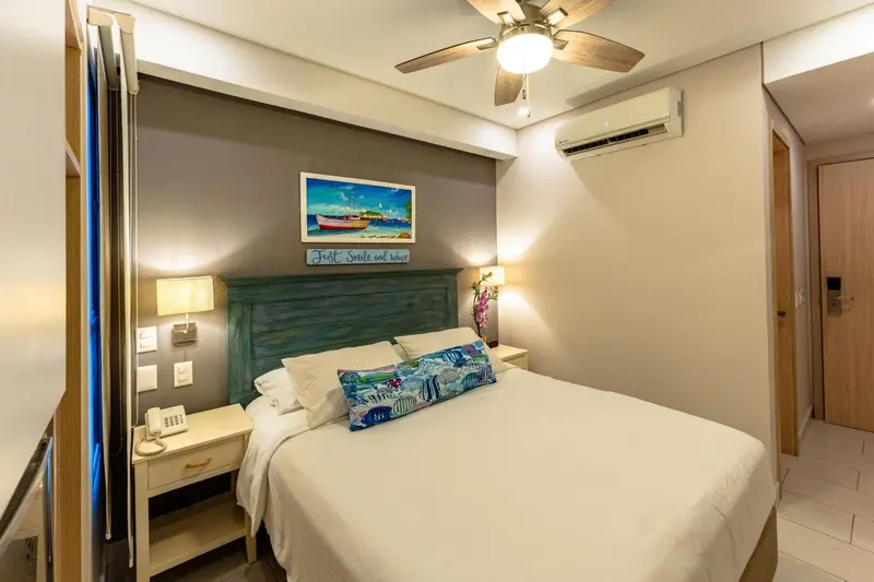 Une chambre lumineuse avec un grand lit et une décoration marine.