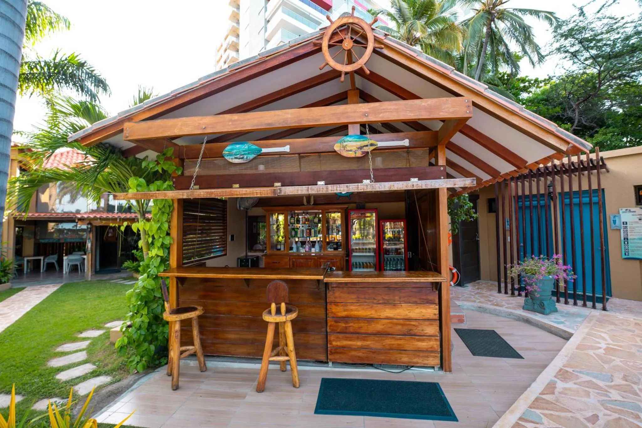 Un bar en plein air avec un comptoir en bois et des tabourets.