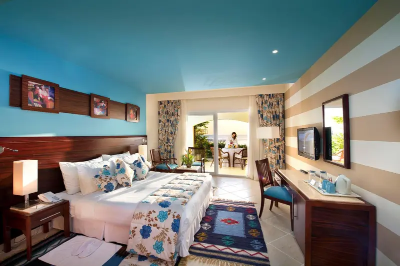 Une chambre lumineuse avec un grand lit et un espace repas.