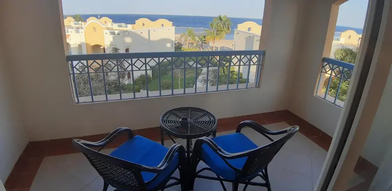 Terrasse avec mobilier de jardin et vue sur la mer.