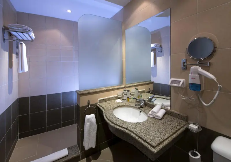 Une salle de bain moderne avec lavabo et miroir.