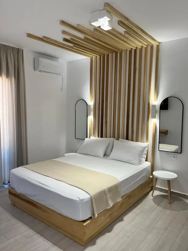 Une chambre lumineuse avec un grand lit et une décoration murale en bois.