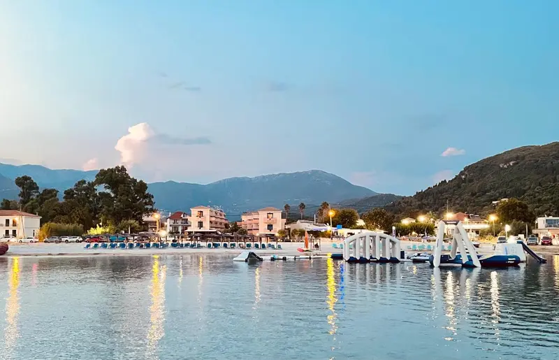 Vue d'une plage au coucher du soleil avec des montagnes en arrière-plan.