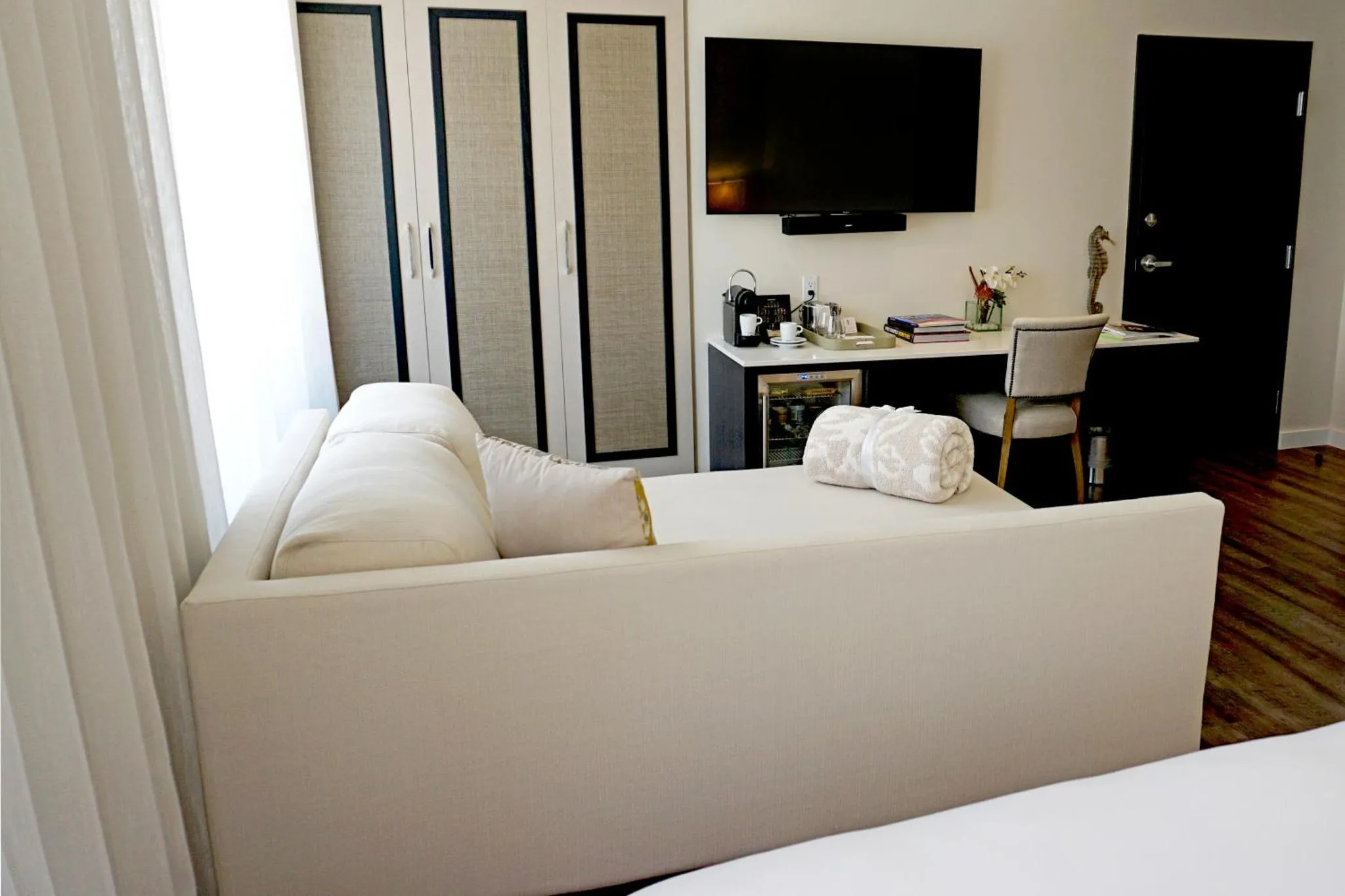 Espace de détente avec canapé et bureau dans une chambre lumineuse.