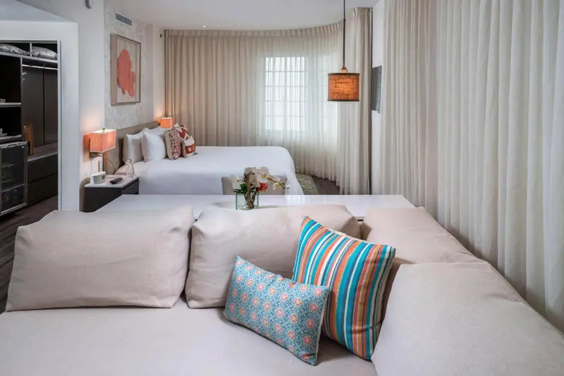 Une chambre lumineuse avec deux lits et un coin salon confortable.