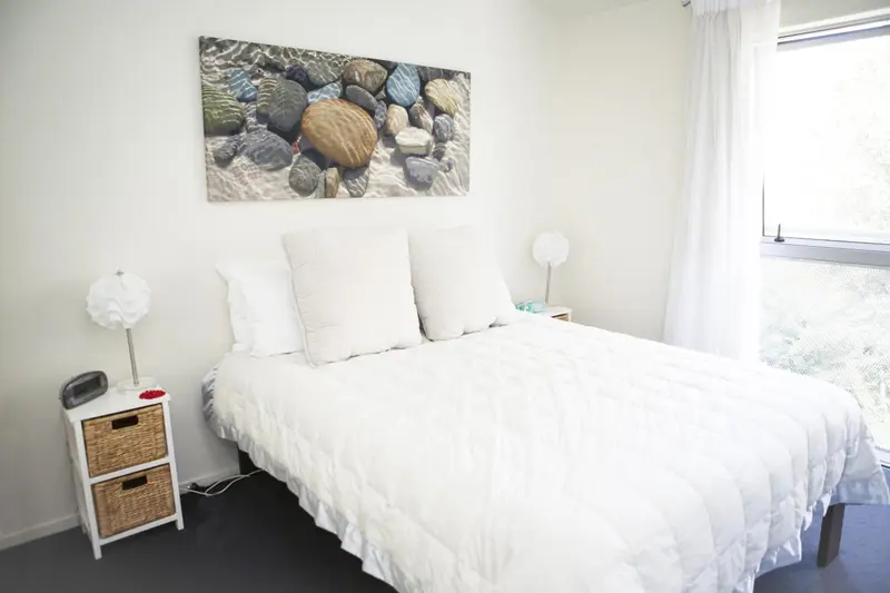 Une chambre lumineuse avec un grand lit recouvert de linge blanc.