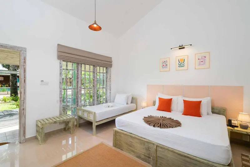 Une chambre lumineuse avec un lit double et un lit simple.