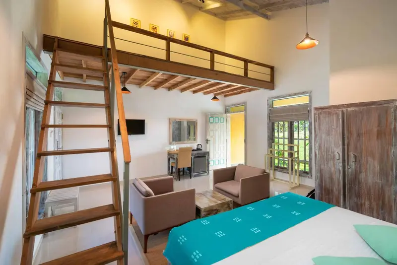 Une chambre lumineuse avec un lit et un espace salon.
