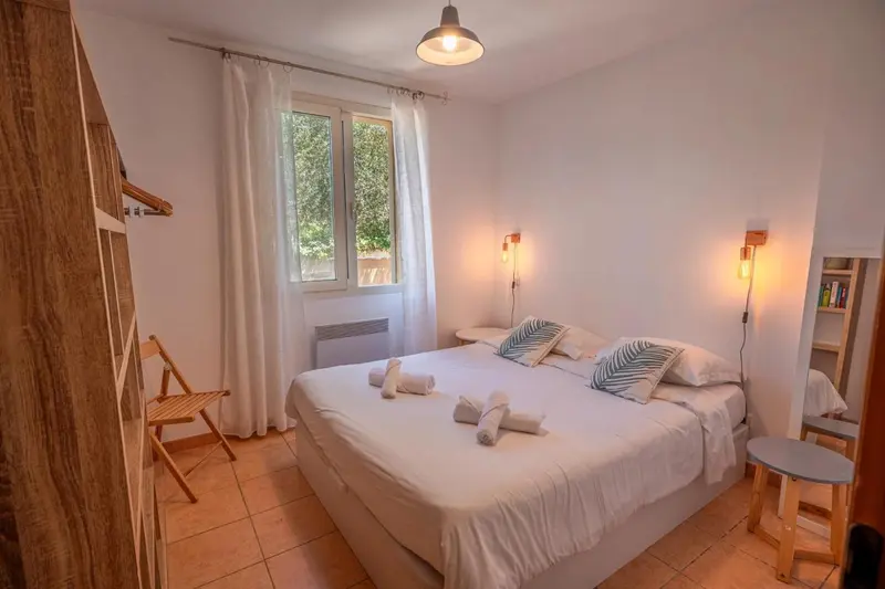 Une chambre lumineuse avec un grand lit et une fenêtre.