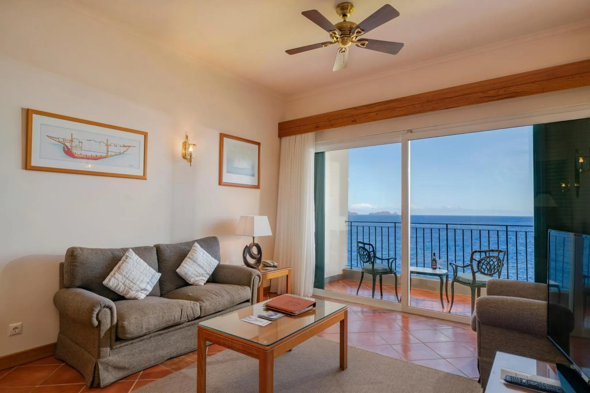 Espace de détente lumineux avec canapé et vue sur la mer.
