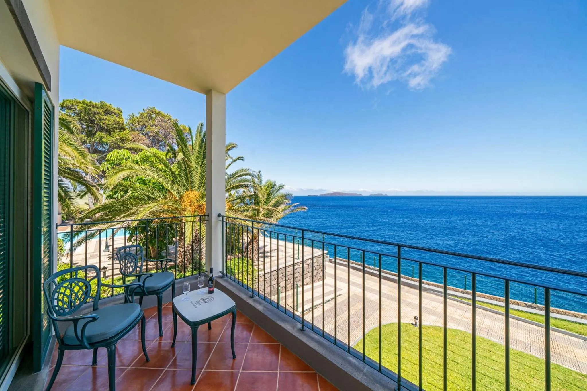Terrasse carrelée avec mobilier de jardin donnant sur la mer.