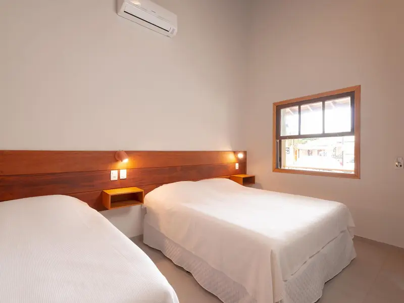 Une chambre lumineuse avec deux lits simples et une fenêtre.