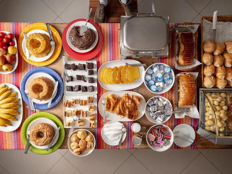 Une table garnie de pâtisseries, de fruits et de viennoiseries.