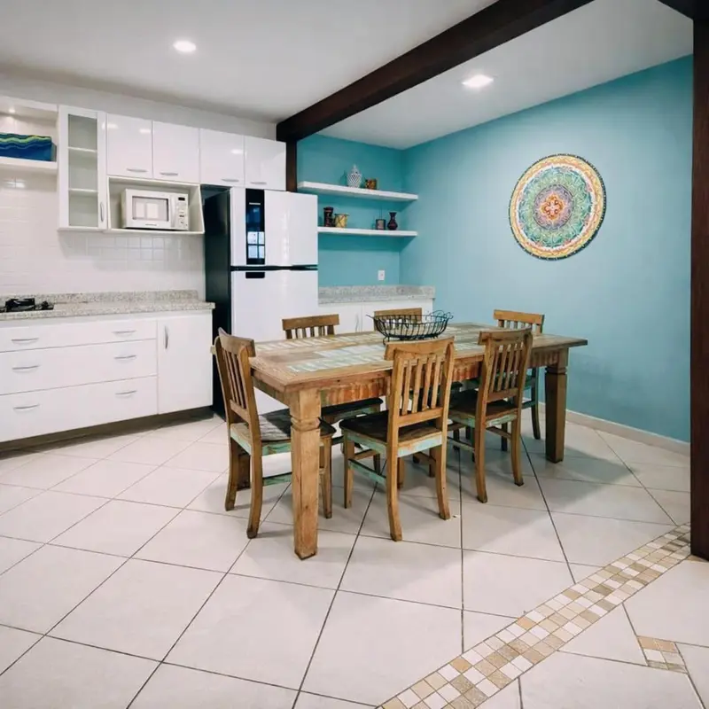 Une salle à manger lumineuse avec une cuisine équipée.