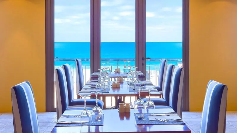 Une salle à manger lumineuse avec une vue sur la mer.