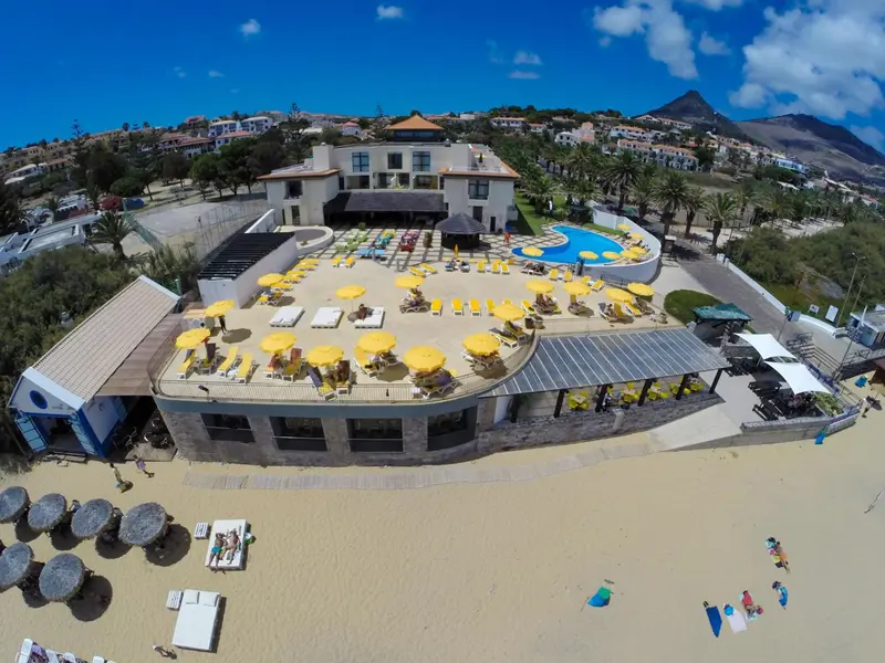 Vue aérienne d'un complexe hôtelier avec piscine et plage.