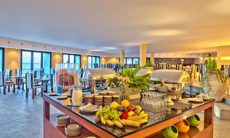 Un buffet généreux est présenté dans une salle lumineuse avec de grandes baies vitrées.