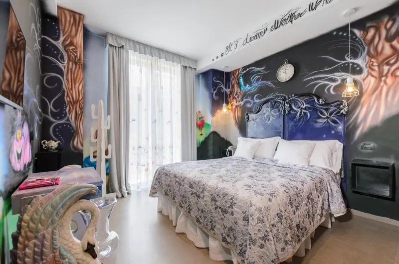 Une chambre décorée de fresques murales aux motifs abstraits et animaliers.