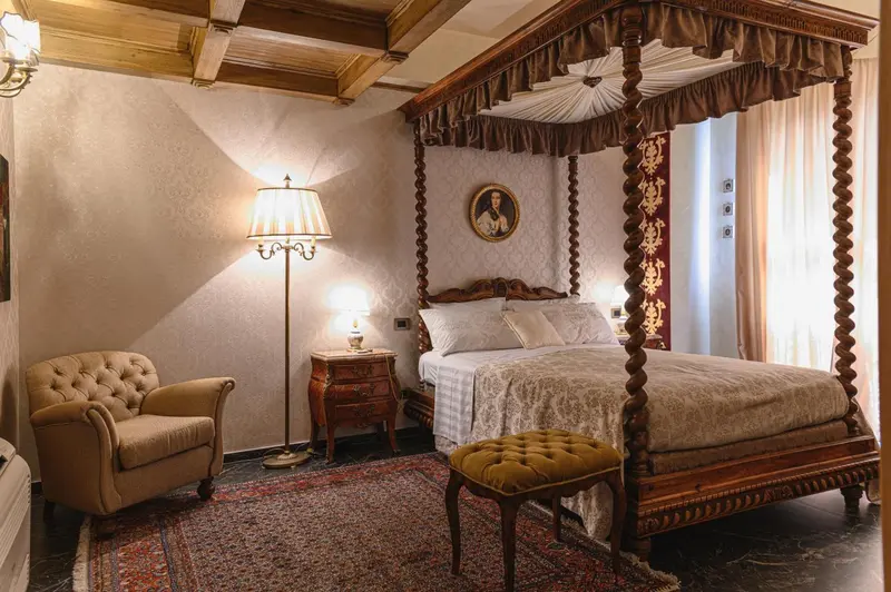 Une chambre à coucher avec un lit à baldaquin et un fauteuil.