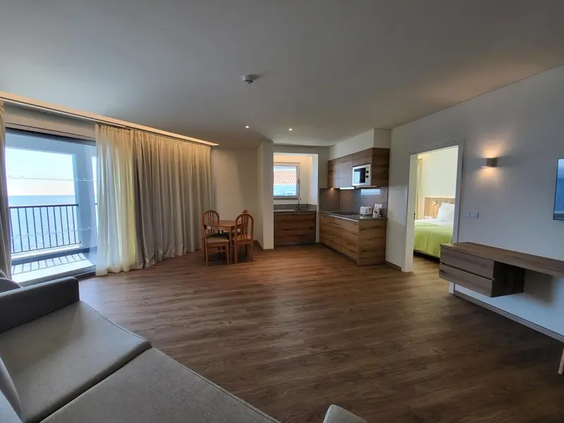 Espace de vie lumineux avec coin repas et cuisine ouverte.