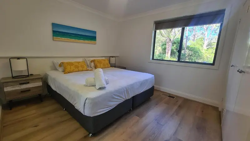 Une chambre lumineuse avec un grand lit et une décoration florale.