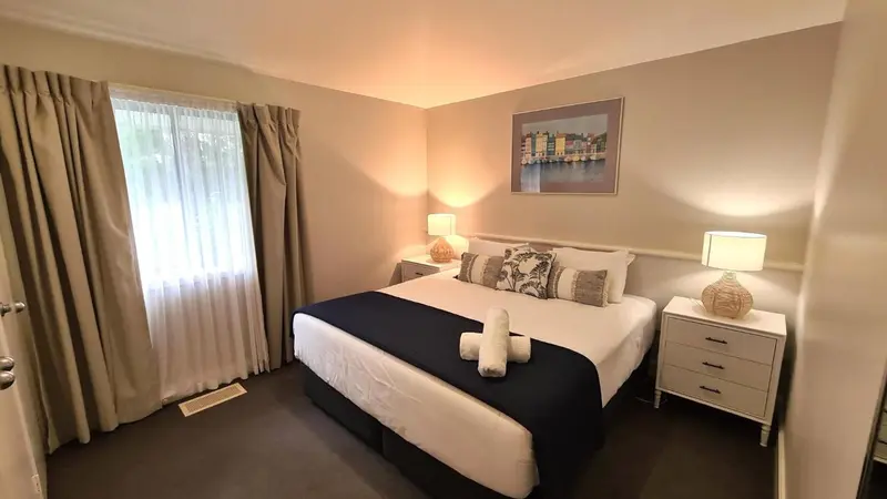 Une chambre lumineuse avec un grand lit et des lampes de chevet.