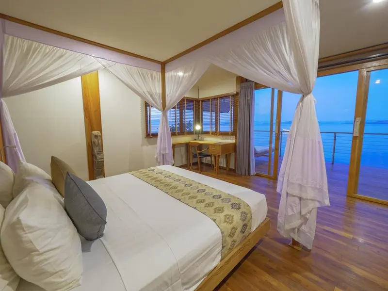Une chambre lumineuse avec un grand lit et vue sur la mer.