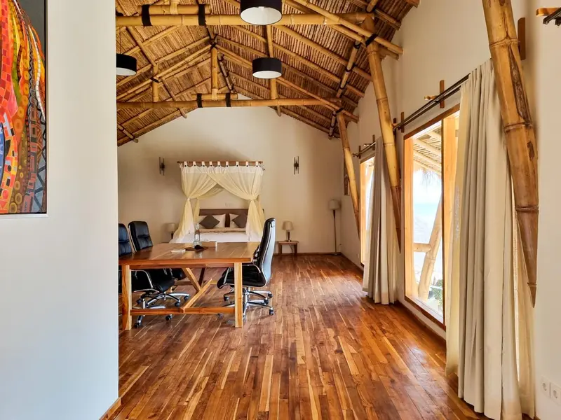 Une pièce lumineuse avec un bureau en bois et un lit à baldaquin.