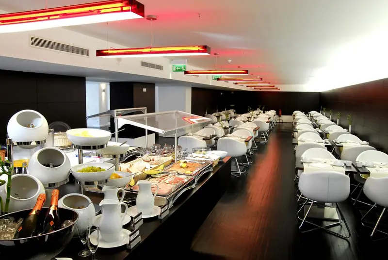 Un buffet propose une variété de plats et de boissons dans une salle lumineuse et moderne.