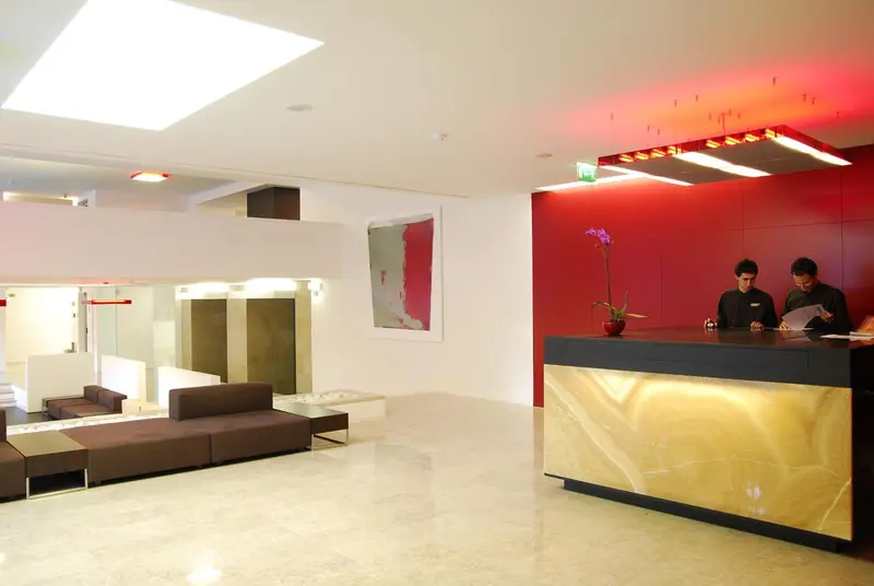 Un comptoir d'accueil moderne avec deux employés et un espace détente.