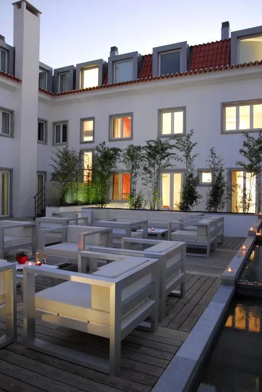 Terrasse aménagée avec mobilier blanc et éclairage tamisé.