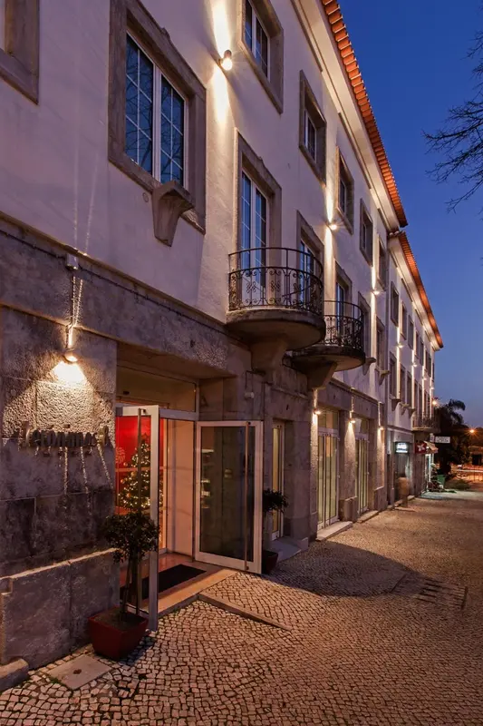 Façade d'un bâtiment avec des balcons et une entrée illuminée.