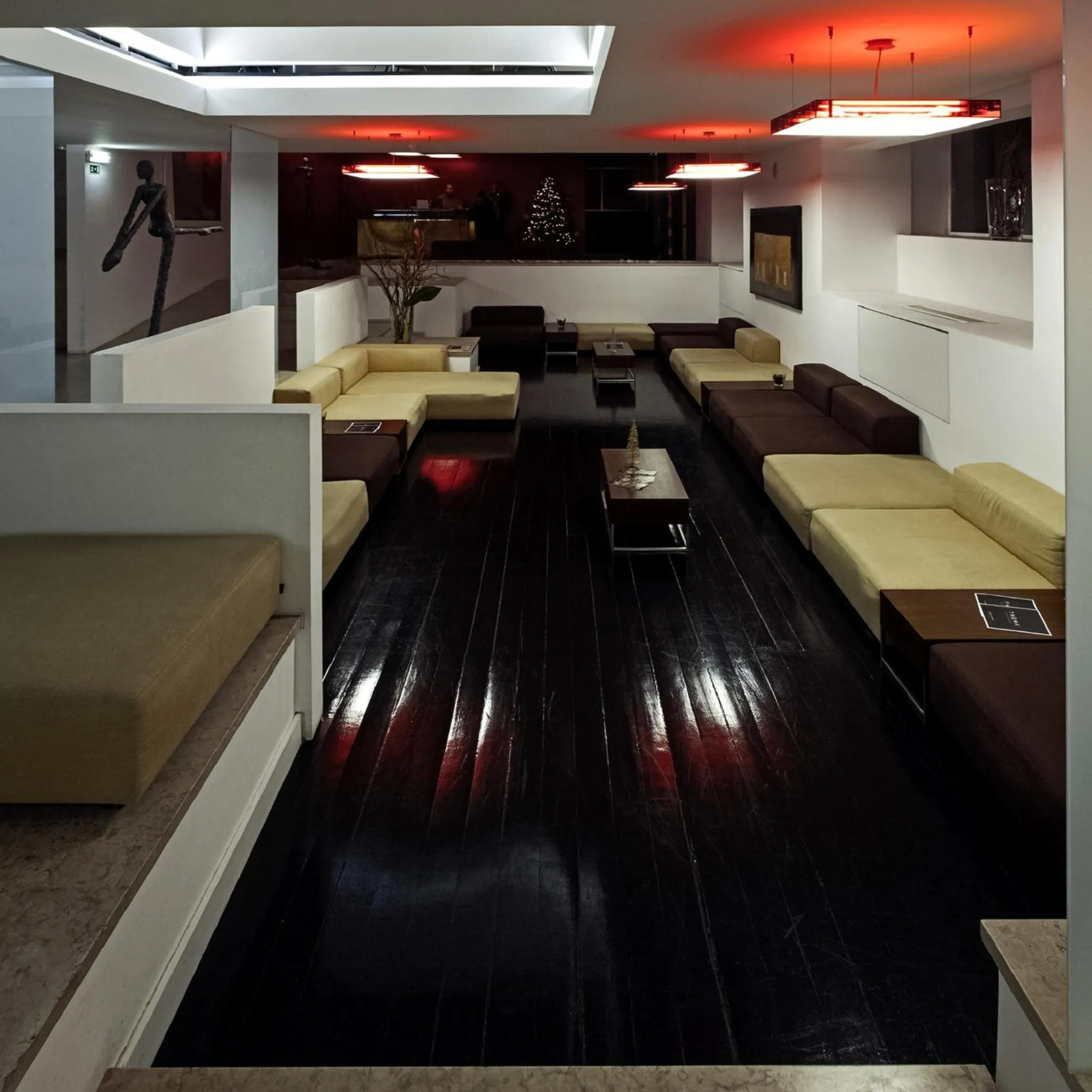 Espace de détente intérieur avec canapés et éclairage moderne.