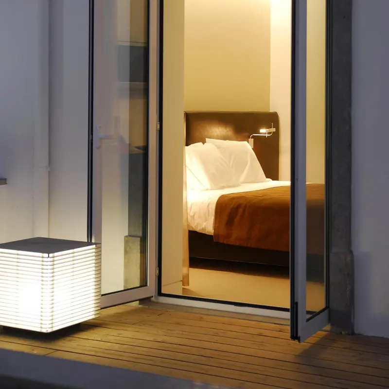 Une chambre lumineuse avec un lit double et une terrasse.