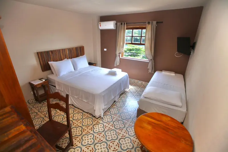 Une chambre lumineuse avec un lit double et un lit simple.