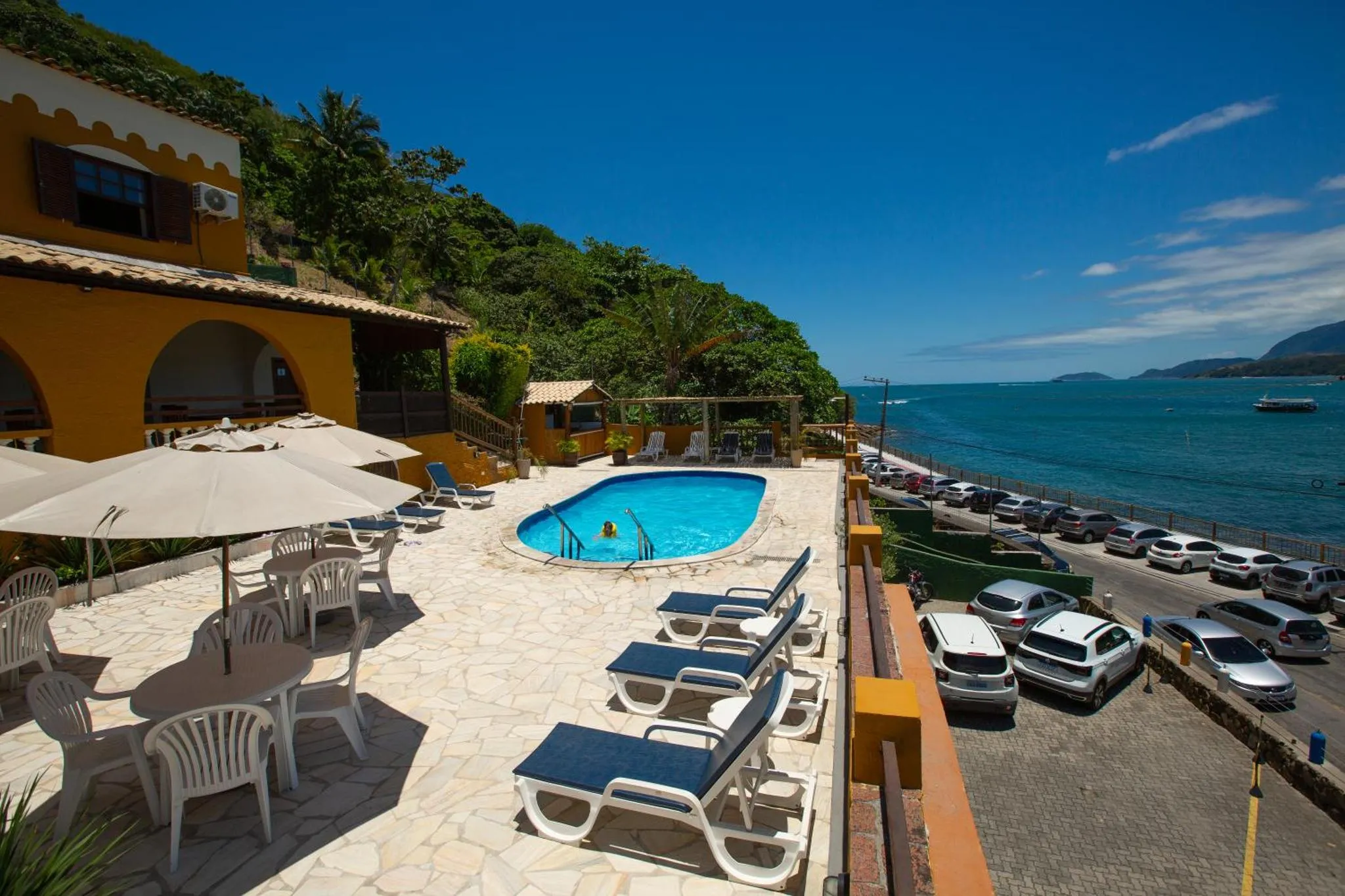 Terrasse avec transats et piscine face à la mer.
