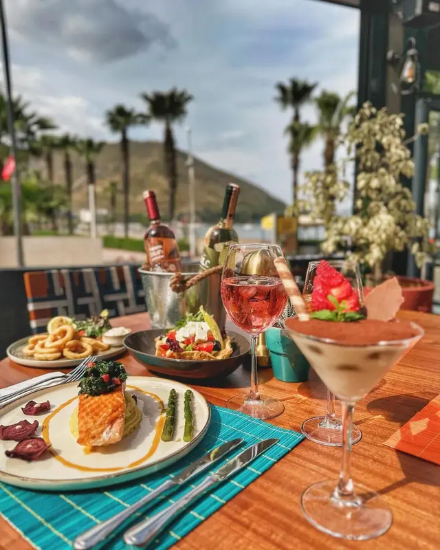Une table est dressée avec des plats et des boissons colorées en extérieur.