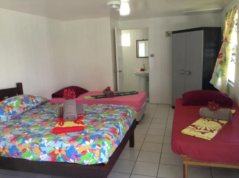 Chambre colorée avec lits décorés de fleurs et armoire.
