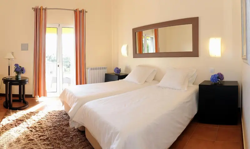 Une chambre lumineuse avec un grand lit et un miroir.