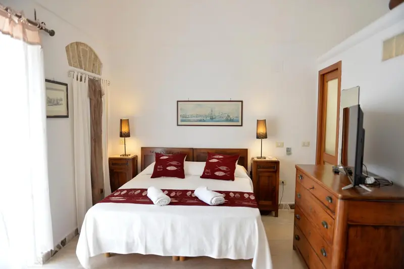 Une chambre lumineuse avec un grand lit et une décoration marine.