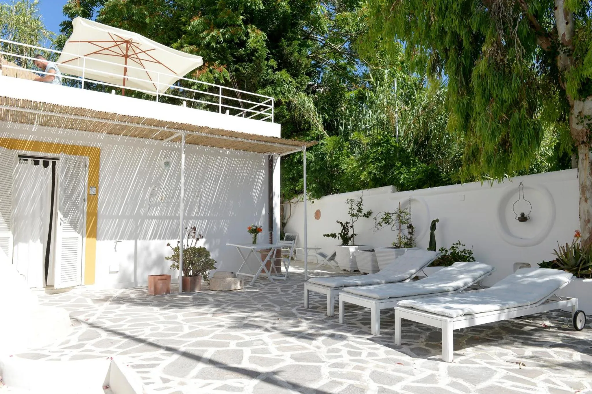 Terrasse ombragée avec mobilier de détente et plantes.