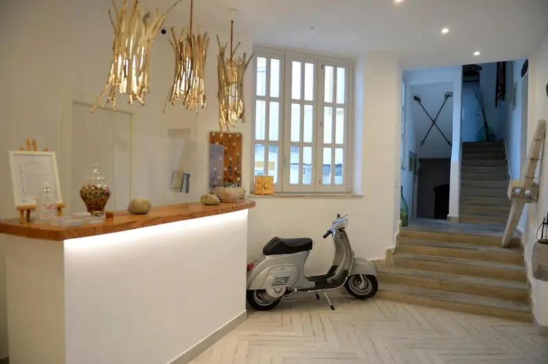 Un comptoir d'accueil en bois clair est éclairé, avec une moto vintage et des éléments décoratifs.