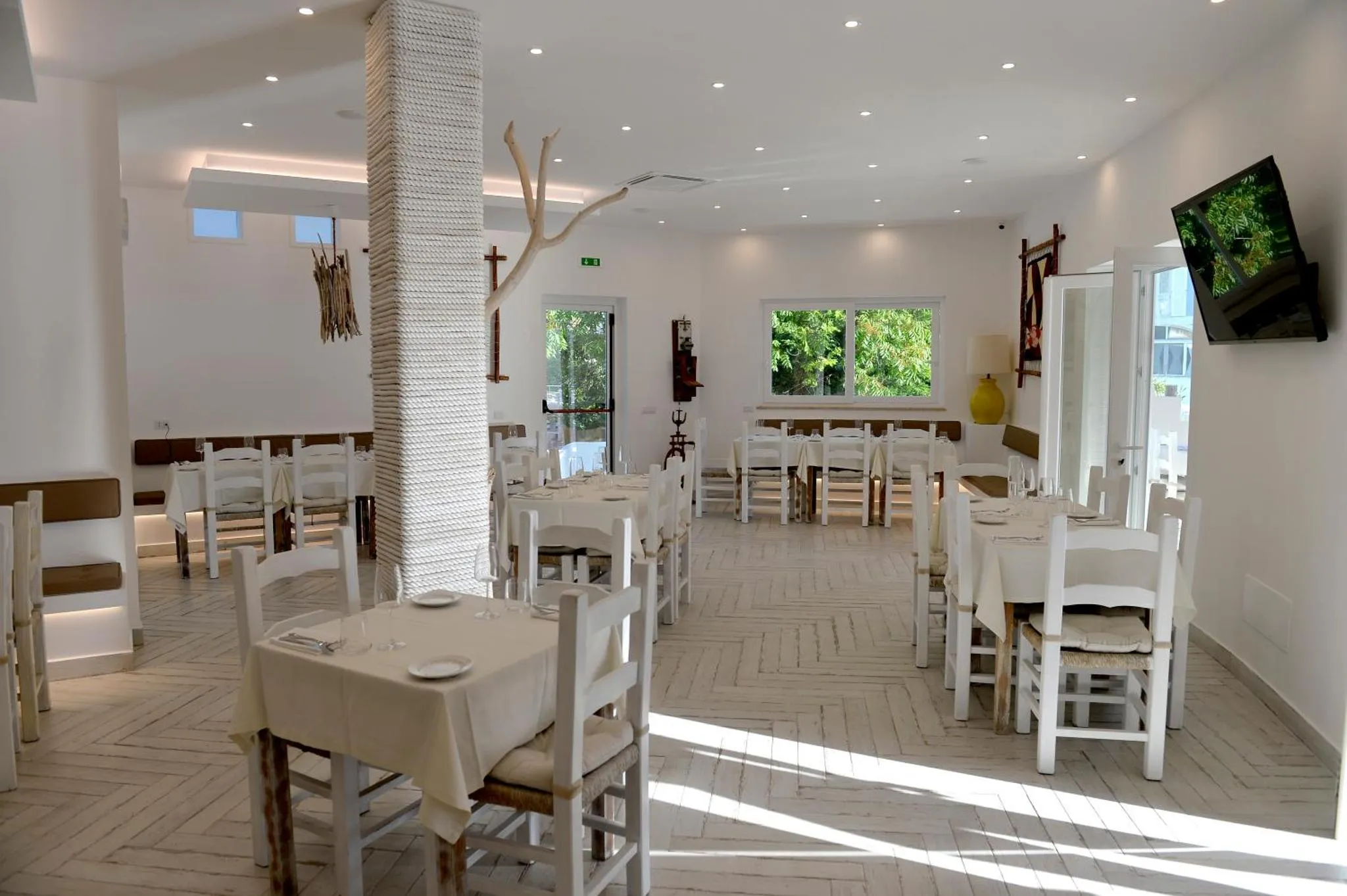 Une salle lumineuse avec des tables dressées pour un repas.