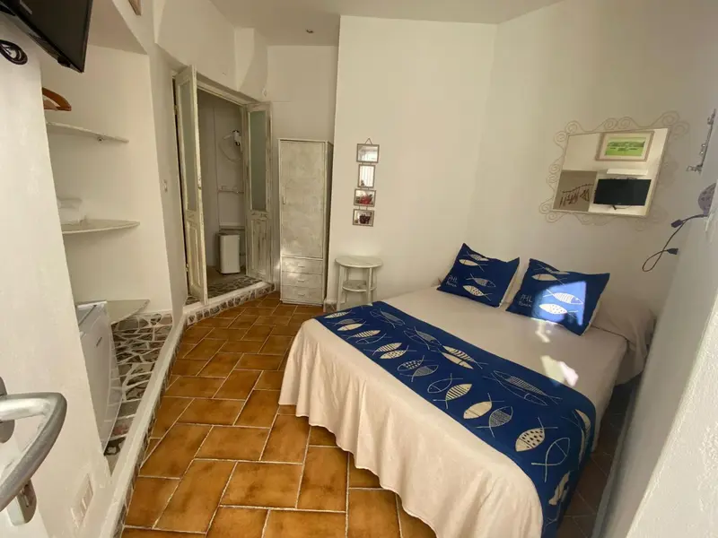 Une chambre lumineuse avec un lit recouvert d'oreillers décoratifs.