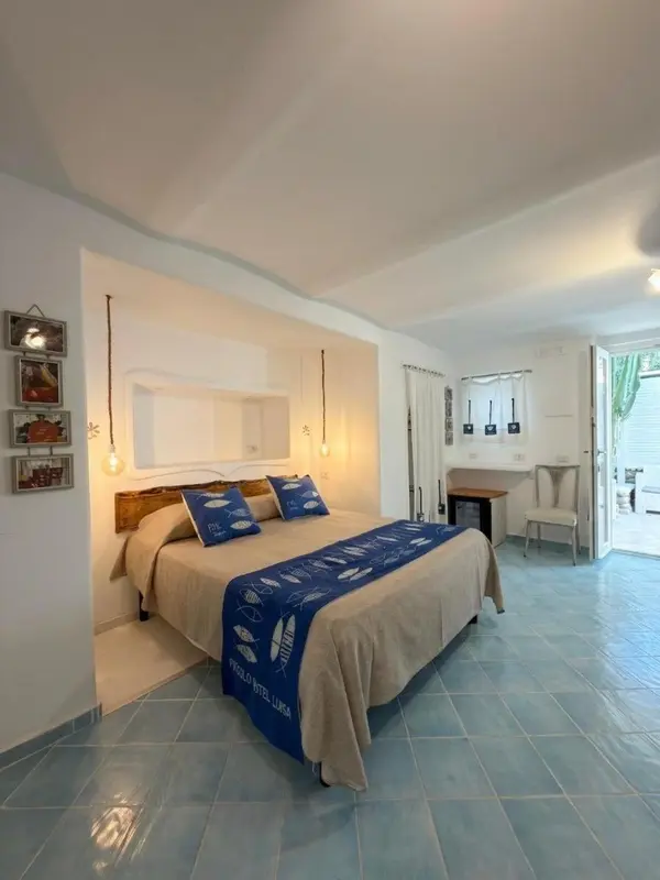 Une chambre lumineuse avec un grand lit recouvert d'une courtepointe décorative.