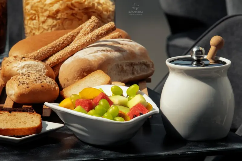 Assortiment de pains, viennoiseries et fruits frais présentés sur un plateau.
