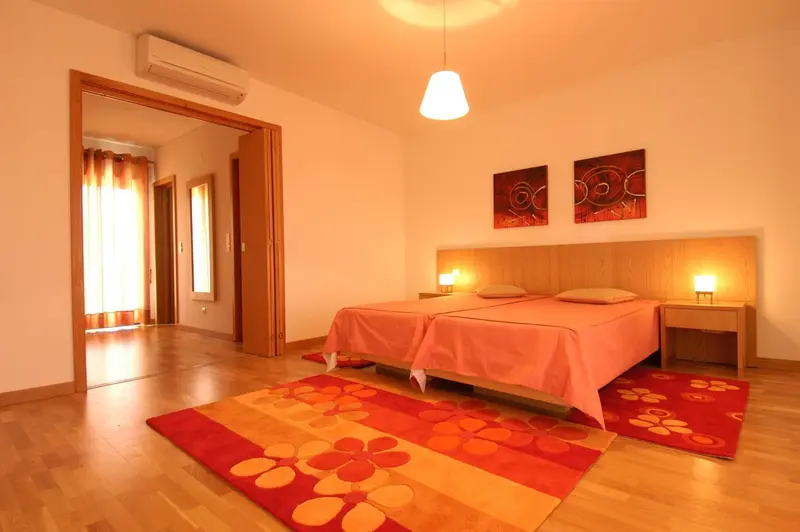 Une chambre lumineuse avec un grand lit et des tableaux décoratifs.